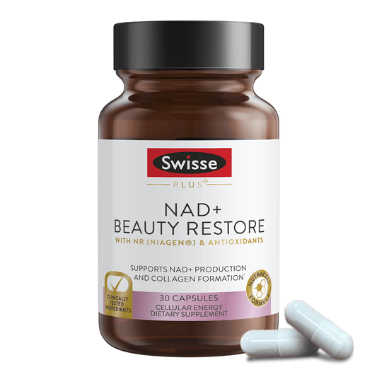 Swisse NAD+ Beauty Restore bottle with white capsules beside it.