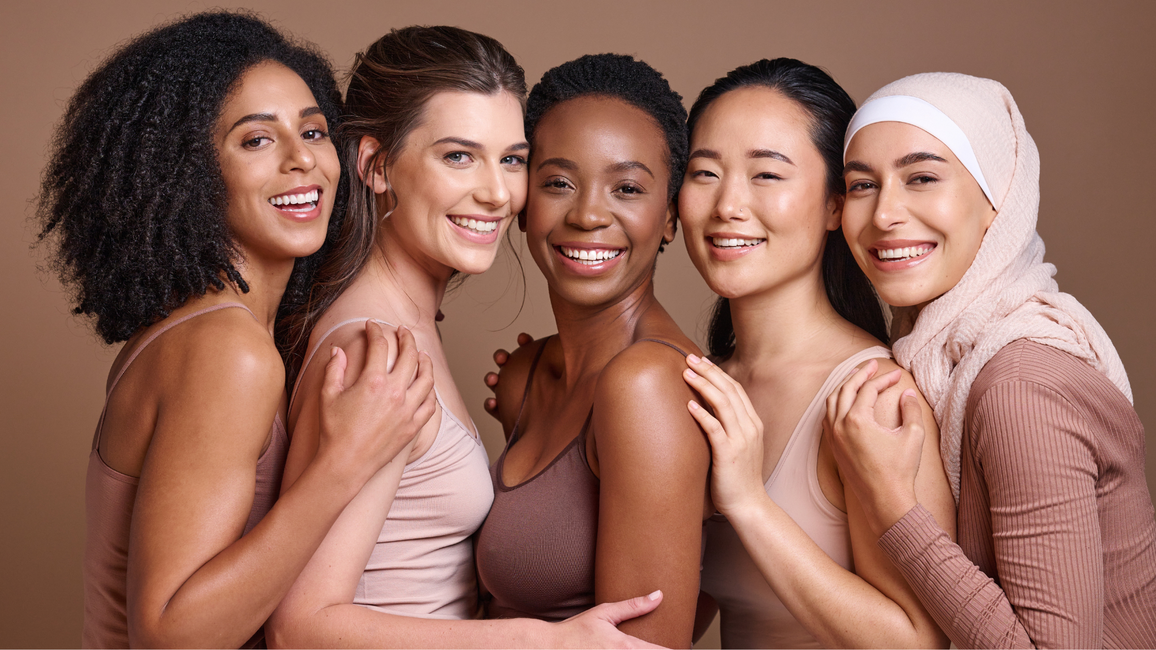 Group of women smiling with a brown background