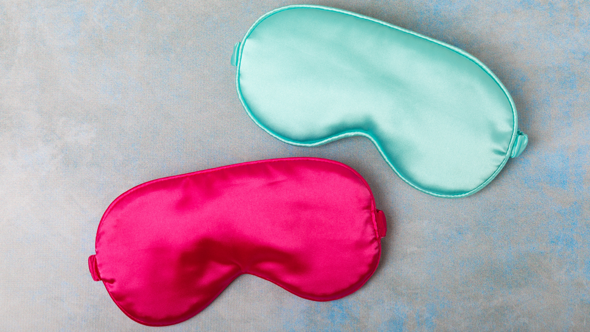 Blue and pink sleeping masks on a marble background
