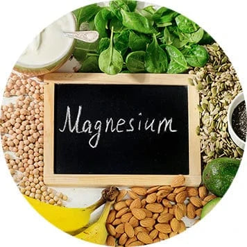Chalkboard labeled ‘magnesium’ surrounded by nuts, seeds, leafy greens, and fruit
