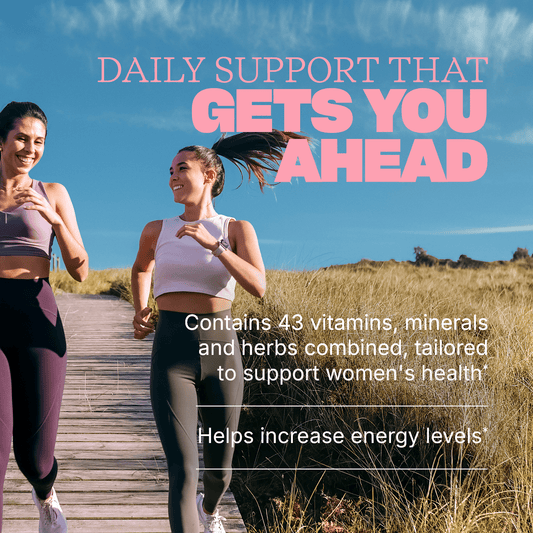 Two women running outdoors on a boardwalk with text reading ‘Daily support that gets you ahead,’ plus benefits: ‘Contains 43 vitamins, minerals and herbs combined, tailored to support women’s health’ and ‘Helps increase energy levels.