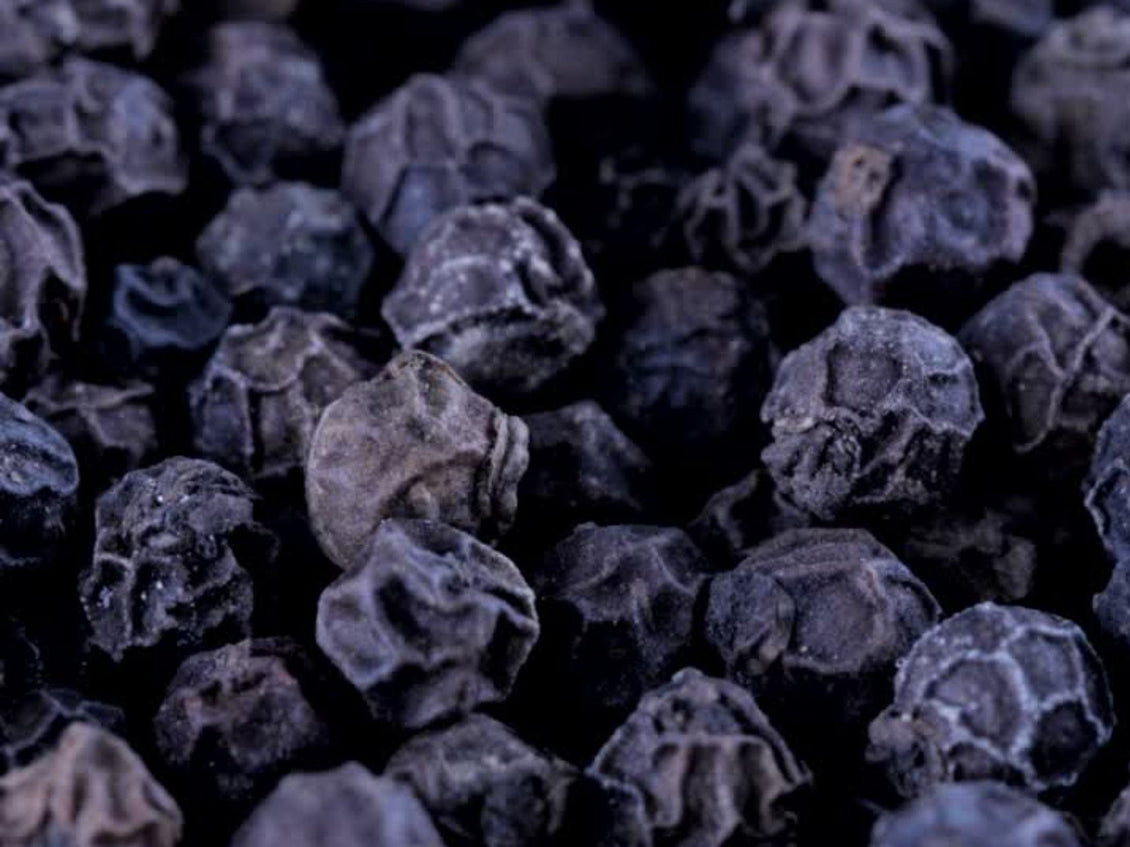 Close-up of whole black peppercorns.