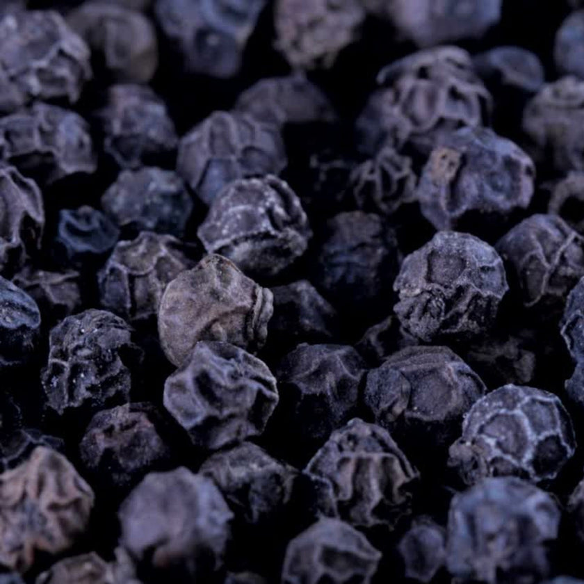 Close-up of whole black peppercorns.