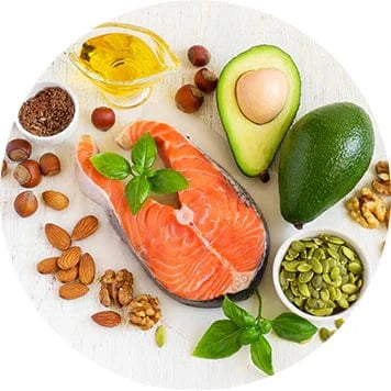 Salmon fillet surrounded by avocado, nuts, seeds, and oil on a light surface